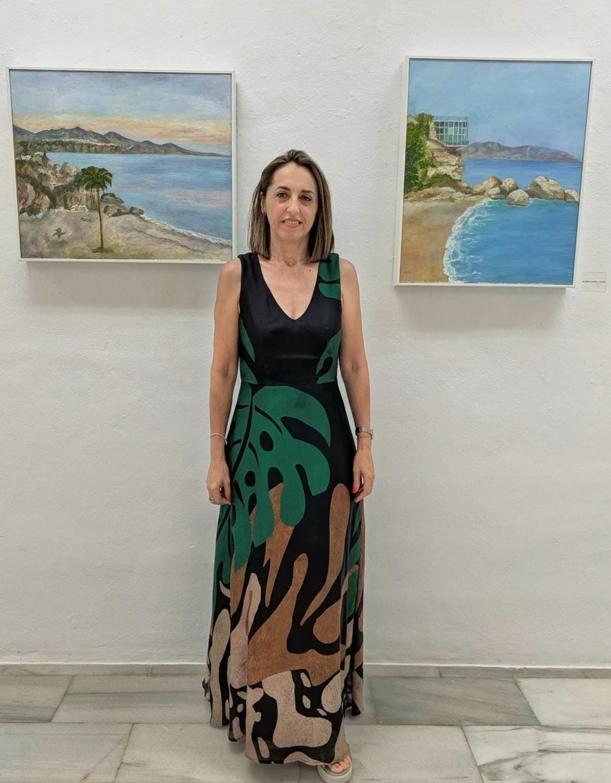 Mónica Nájera Martínez junto a dos de sus óleos en la sala de exposiciones.