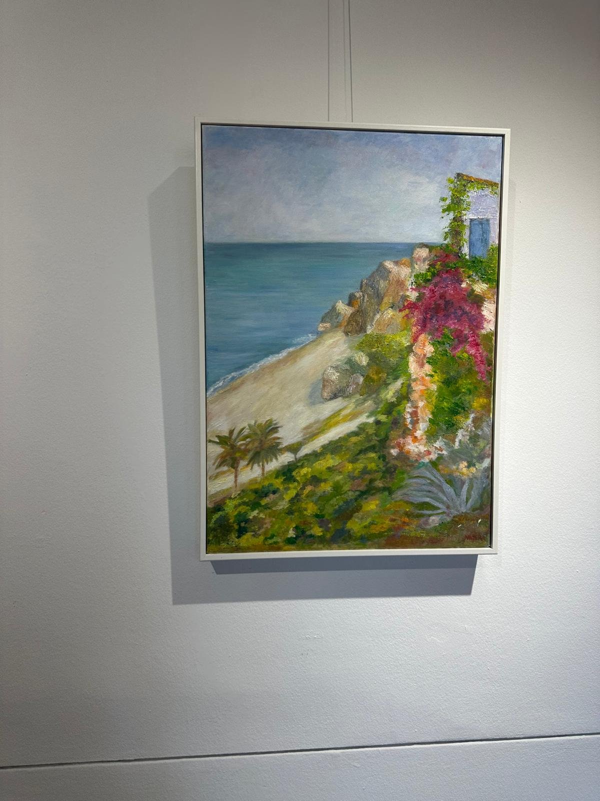 Óleo de un sendero con buganvillas, una puerta azul y palmeras frente al mar.